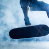 A skateboarder performing a trick in a smoky environment with dramatic lighting. 